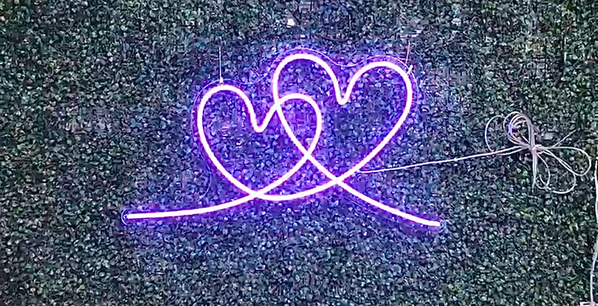 A custom neon light of a purple interlocking heart