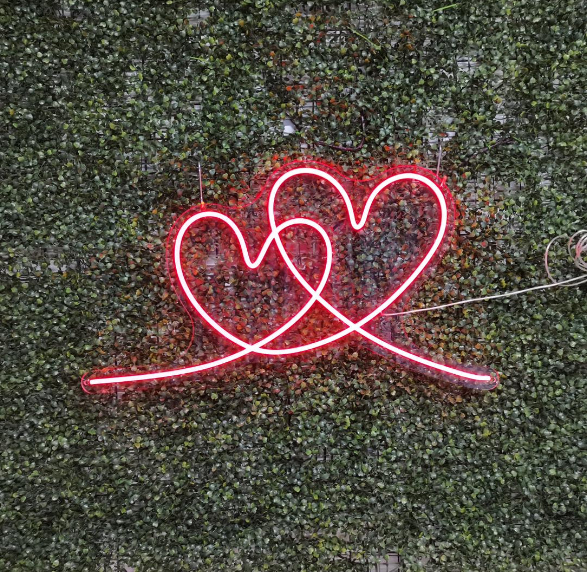 A custom neon light of a red interlocking heart