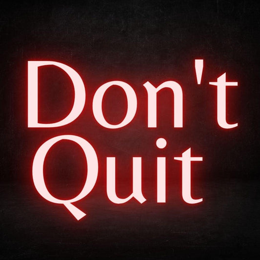 A red custom neon light with the text don't quit