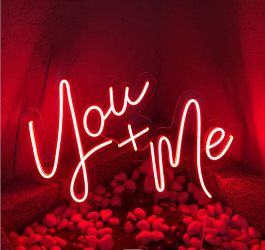 A custom neon light with the text you and me in red